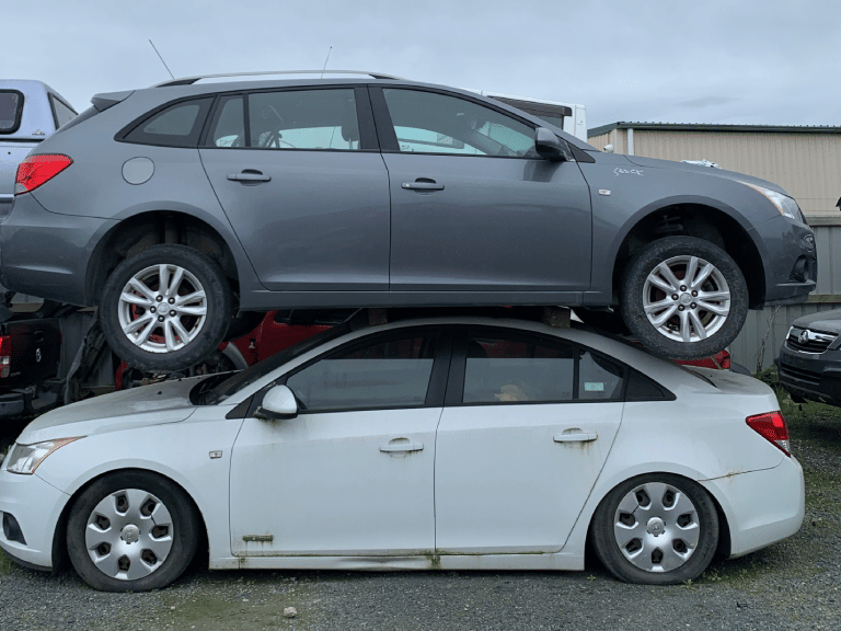 A pile of discarded cars at Car Wreckers Cambridge by Atlas Auto.