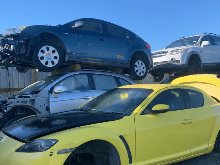 A wrecked car being dismantled by professionals at Car Wreckers Taupo, operated by Atlas Auto